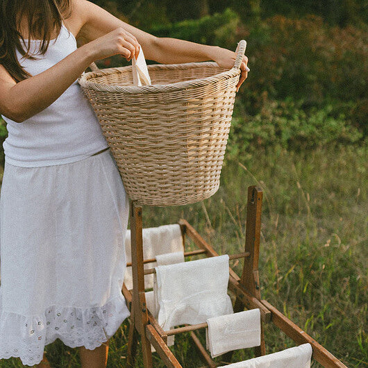Hand-woven seagrass basket held by a woman in a garden
