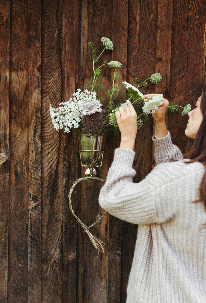 Opal Wall Vessel holding wild flowers on a wood-panelled wall
