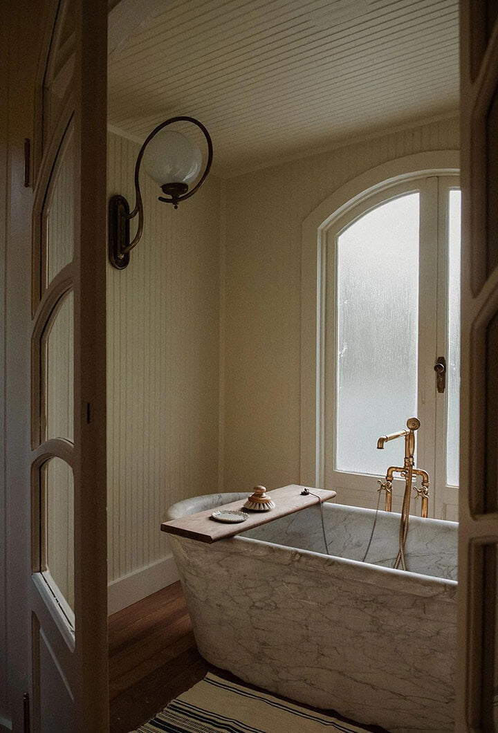 Bathroom with a stone tub and arched window