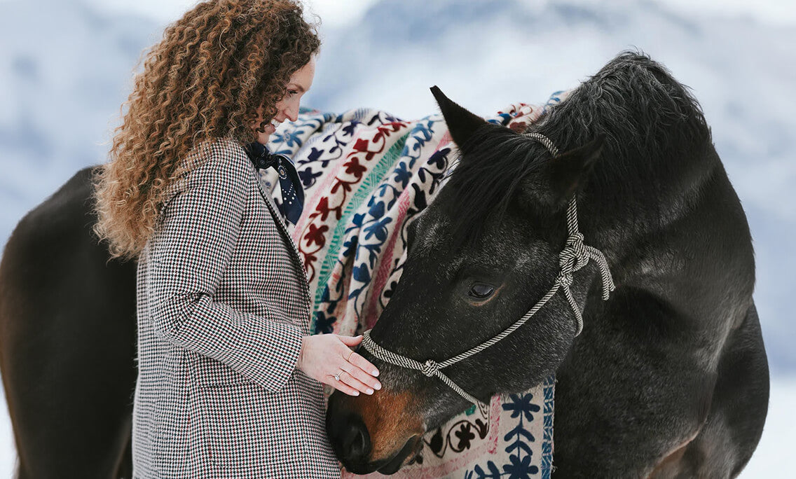 Nicole, founder of Roan Iris, with a horse in the Montana snow